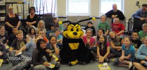 FSB's Buzzy Bee sitting with local students