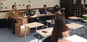 A panel of bankers teach students in school about financial education