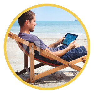 Man casually sitting on the beach with tablet