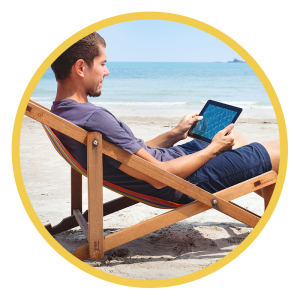 Man casually using a tablet on the beach