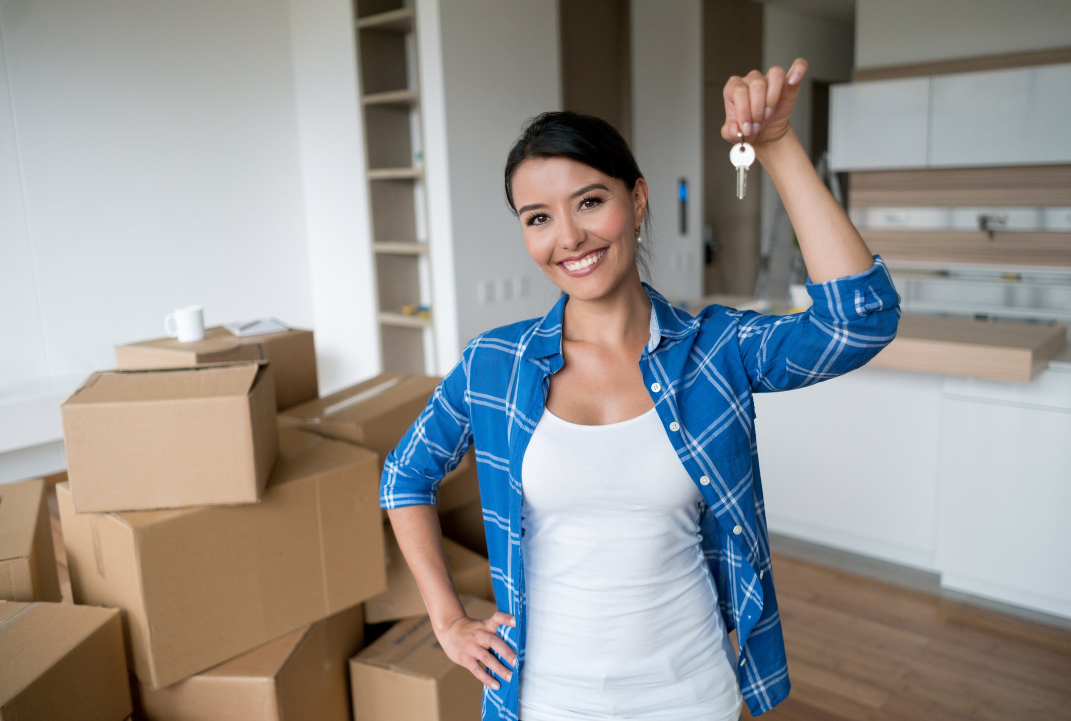 Young woman who moved into a new home holding a key