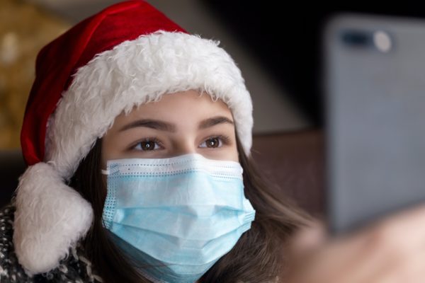 Woman with mask wearing santa hat
