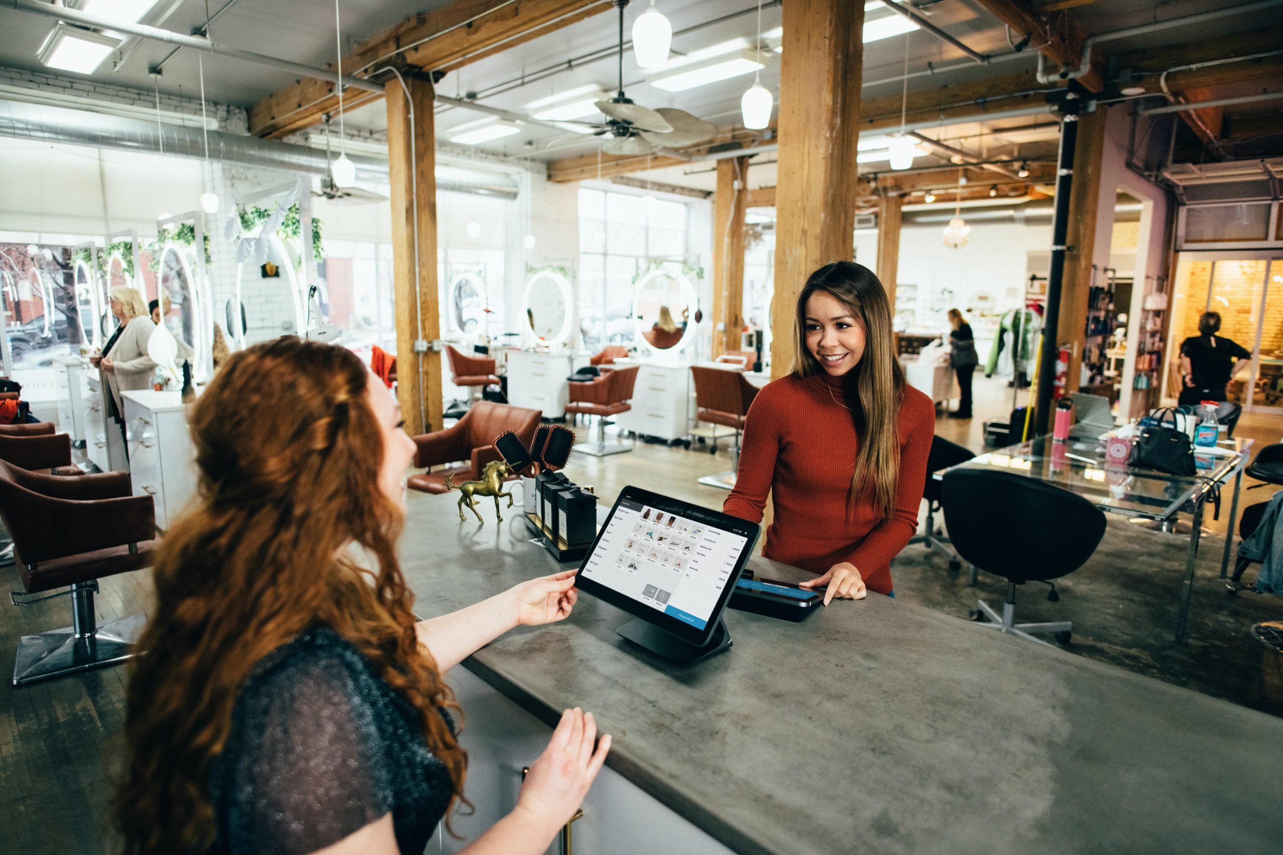 Woman checking someone out at her shop