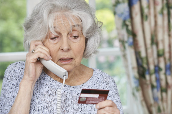 Elderly woman on the phone with credit card