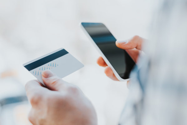 Person holding phone and credit card