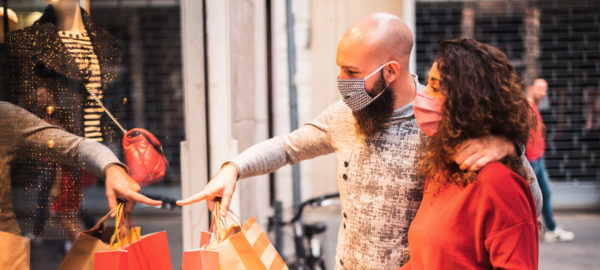 Young couple holiday shopping with face masks