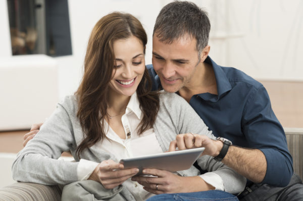 Shows a couple working together on a tablet