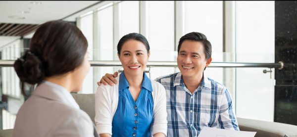 Asian couple talking with a banker.