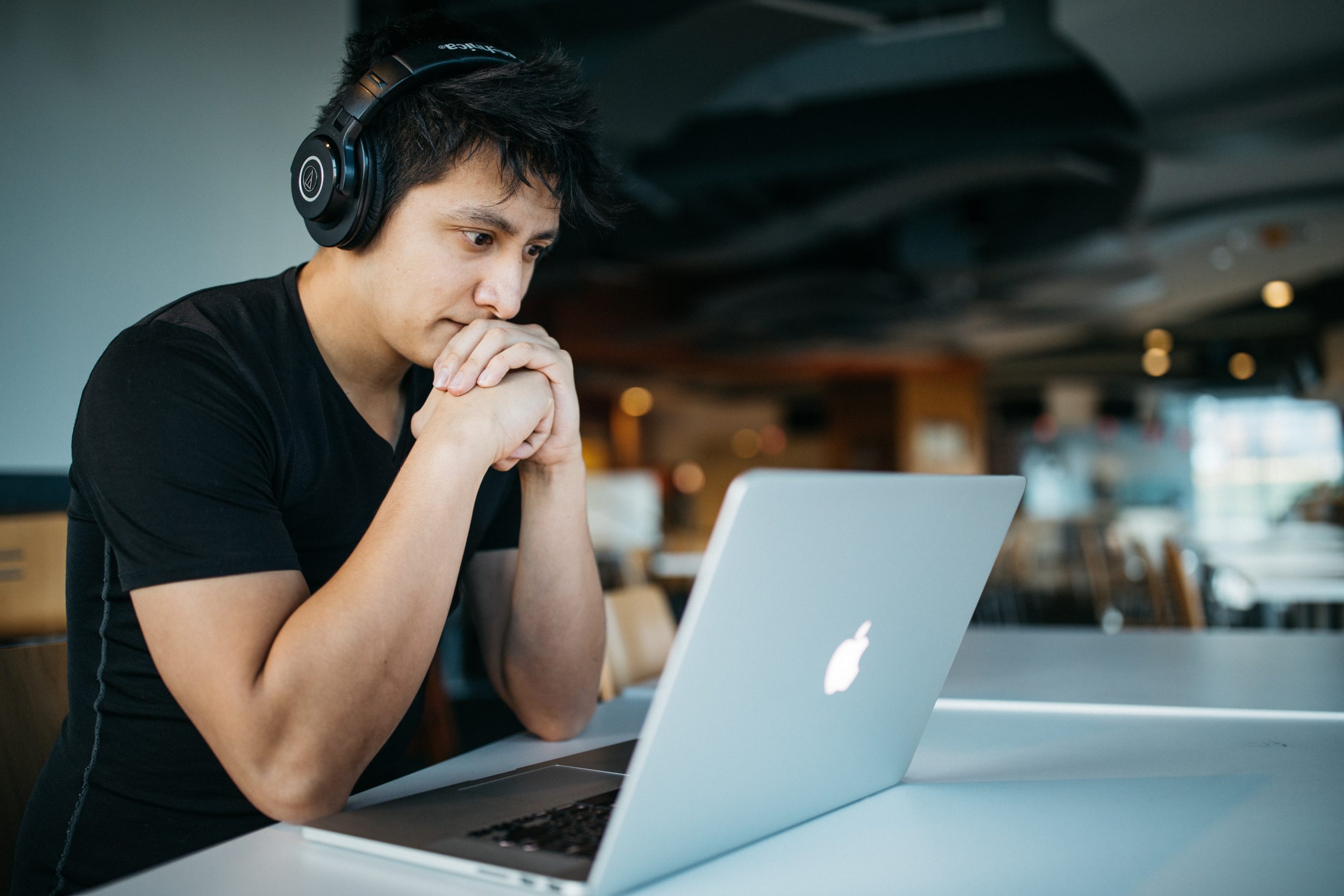 Male student with headphones and laptop