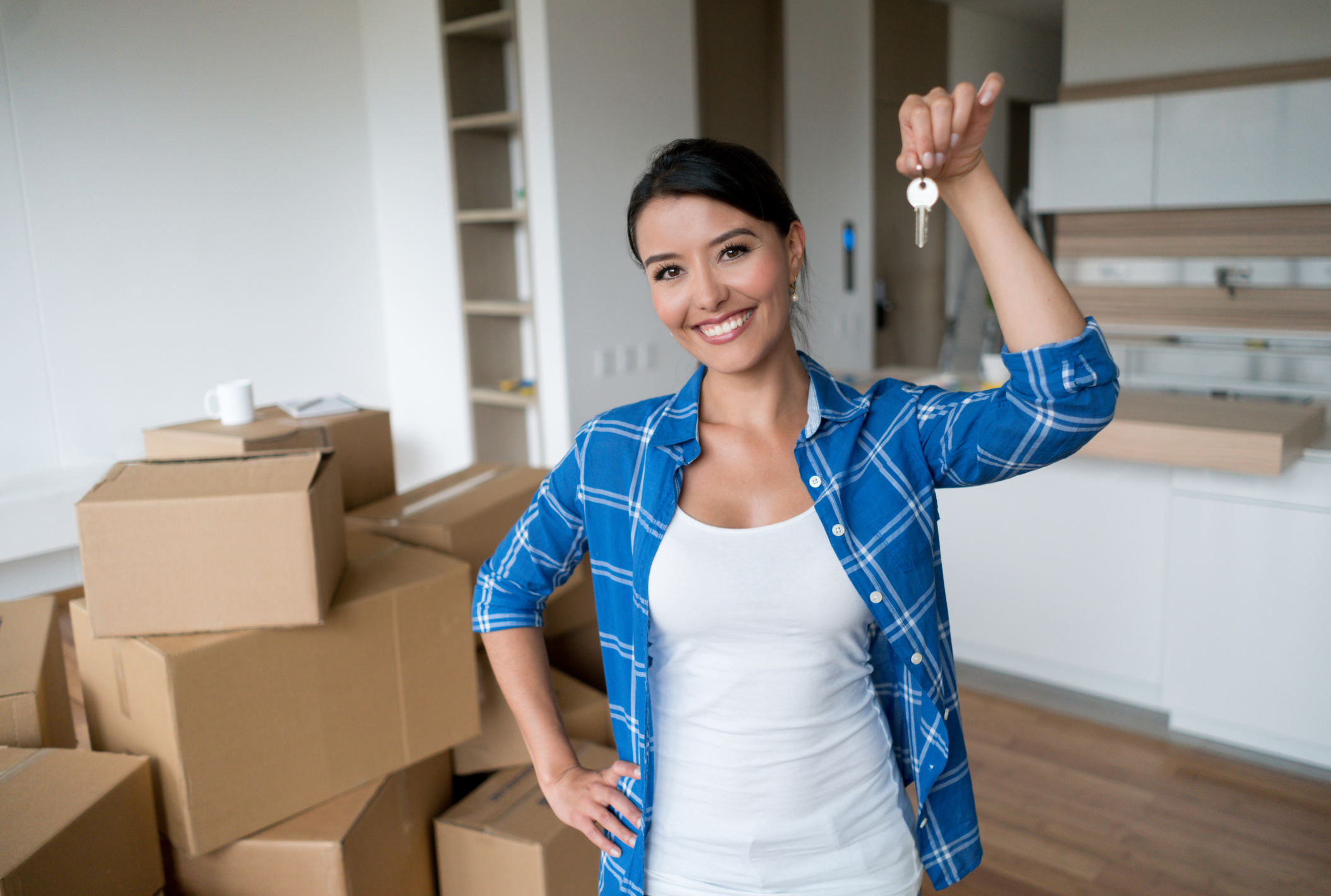 Young woman holding the keys to her new home.