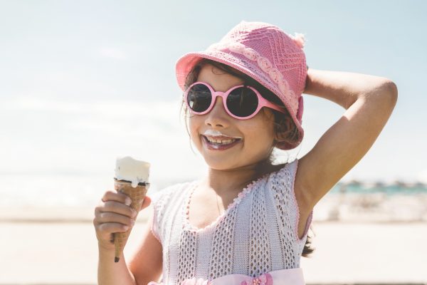 Happy Little Child Girl Enjoying Eating Ice Cream at Beach in Summer