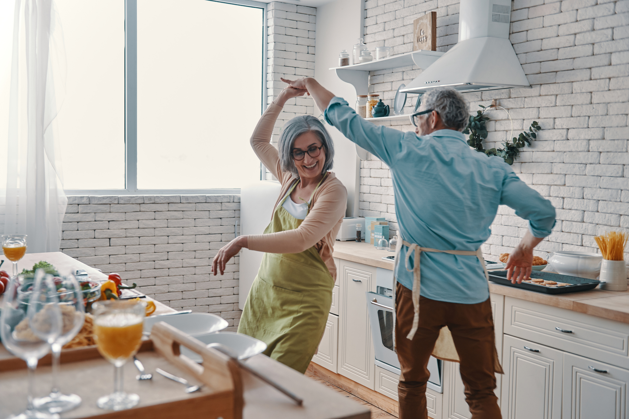 Image of an older couple dancing in the kitchen